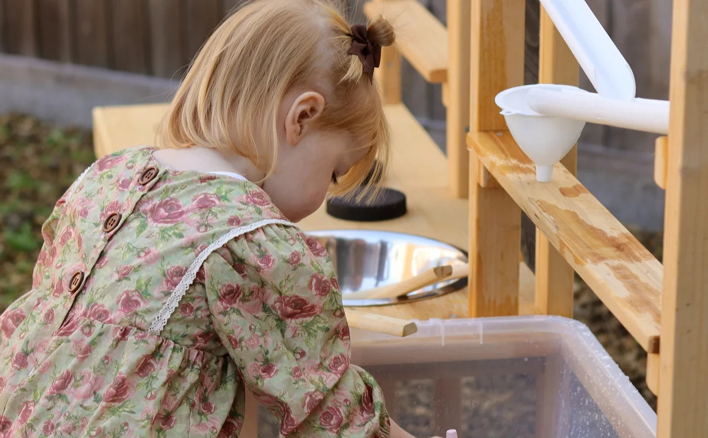 Little girl playing with water run on table